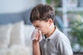 Sick boy blowing nose into tissue, Unhealthy child suffering from running nose Royalty Free Stock Photo