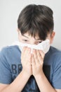Sick Boy Blowing Nose with Kleenex Tissue Royalty Free Stock Photo