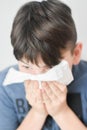 Sick Boy Blowing Nose with Kleenex Tissue Royalty Free Stock Photo