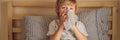 Sick boy coughs and wipes his nose with wipes. Sick child with fever and illness in bed BANNER, LONG FORMAT Royalty Free Stock Photo