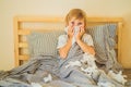 Sick boy coughs and wipes his nose with wipes. Sick child with fever and illness in bed Royalty Free Stock Photo