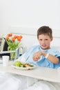 Sick boy having food in hospital bed Royalty Free Stock Photo