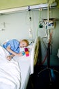 Sick boy in hospital bed with his toy Royalty Free Stock Photo