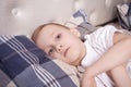 Sick boy lies in bed and doesn t feel well Royalty Free Stock Photo