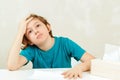 Sick boy sitting at the desk. Boy has a virus, runny nose and headache. Healthcare and childhood Royalty Free Stock Photo