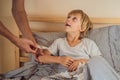 Sick boy with thermometer laying in bed and father hand taking temperature. father checking temperature of her sick son Royalty Free Stock Photo