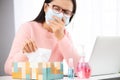 Sick business woman hand taking white tissue paper while cough. Laptop mouse smartphone, sanitizer gel, medical face mask, and