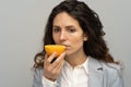 Sick business woman trying to sense smell of half fresh orange, has symptoms of Covid-19 Royalty Free Stock Photo