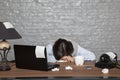 Sick businesswoman fell asleep on the desk with exhaustion