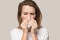 Sick young woman use tissue blowing runny nose Royalty Free Stock Photo