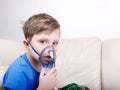 Sick chid with pediatric nebulizer looking at camera