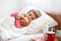 Sick child boy lying in bed with a fever, resting Royalty Free Stock Photo