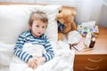 Sick child boy lying in bed with a fever, resting Royalty Free Stock Photo