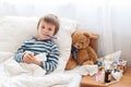 Sick child boy lying in bed with a fever, resting Royalty Free Stock Photo