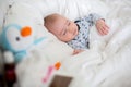 Sick child boy lying in bed with a fever, resting at home Royalty Free Stock Photo