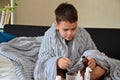 Sick child boy lying in bed with a fever, resting at home. a boy with a cold, treated. medicines, throat nose spray Royalty Free Stock Photo