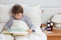 Sick child boy lying in bed with a fever Royalty Free Stock Photo