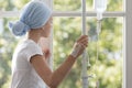 Sick child with drip wearing blue headscarf in the hospital