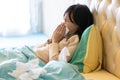 Sick child girl have a cold,blowing nose in paper handkerchief in bedroom,flu or the weather is changing,asian female teenage Royalty Free Stock Photo