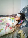 Sick child with high fever laying in bed. Compress gel on forehead Royalty Free Stock Photo