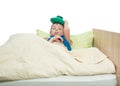 Sick child lies in bed with a thermometer in his mouth and on his head holds an ice pack