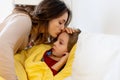 Sick child, toddler boy lying in bed with a fever, having breakfast, resting at home Royalty Free Stock Photo