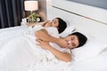 Sick couple sneezing and suffering from virus disease and fever on bed Royalty Free Stock Photo