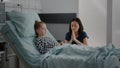 Sick daughter sleeping after recovery surgery while worried mother prating for healthcare treatment Royalty Free Stock Photo