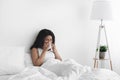Sick day at home. Ill african american woman has runny nose, cough and cold, blowing nose, sitting in bed, copy space Royalty Free Stock Photo