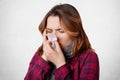 Sick desperate woman has flu, running nose, blows nose in handkerchief, has terrible headache, caught cold after long walk outside