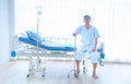 The sick  or elderly Asian old man sitting alone on the patient bed with walking stick waiting for the doctor Royalty Free Stock Photo