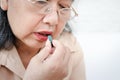 Sick elderly Asian woman Take medications to treat illnesses.