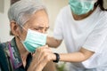 Sick elderly woman with coughing and fever,risk symptoms of flu,pandemic of Covid-19, asian daughter wearing protective mask to Royalty Free Stock Photo