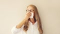 Sick exhausted middle-aged woman employee sneezing blow nose using tissue