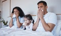 Sick, family and blowing nose in bed in home lying in bedroom together in house. Flu, parents and child wipe with tissue