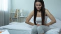 Sick female feeling sharp pain in abdomen, miscarriage danger, induced abortion