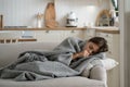 Sick girl child covered with blanket lying on sofa at home coughing, having chills shivering Royalty Free Stock Photo