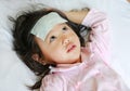 Sick girl lying on the bed with a cool jell in the face Royalty Free Stock Photo