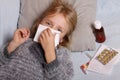 Sick girl lying in bed with a thermometer and medicine. Child winter flu allergy health care concept Royalty Free Stock Photo