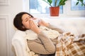 Sick girl lying on the couch with a runny nose Royalty Free Stock Photo