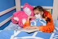 Sick girl in medical mask fell asleep in bed Royalty Free Stock Photo