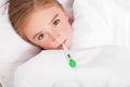 Sick girl resting in bed with fever meassuring temperature with