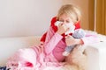 Sick girl with runny nose sitting in sofa Royalty Free Stock Photo