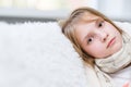 Sick girl with scarf looking at camera