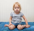 A sick girl is sitting near the bed