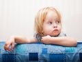 A sick girl is sitting near the bed