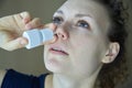 Sick girl sprays the spray from runny nose into the nasal pass Royalty Free Stock Photo