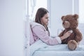 Sick girl with stethoscope examining teddy bear in the hospital Royalty Free Stock Photo