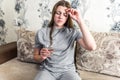 Sick girl suffering from head migraine, feeling pressure and stress. Woman holding pill and glass of water