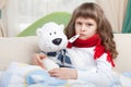 Sick girl with thermometer embraces toy in bed Royalty Free Stock Photo